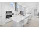 Bright, modern kitchen with stainless appliances, white cabinets, and an island with barstool seating at 28761 Sweet Persimmon Dr, Wesley Chapel, FL 33543