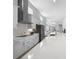 Long shot of the kitchen featuring an island with a sink, stainless appliances, and white cabinets at 28761 Sweet Persimmon Dr, Wesley Chapel, FL 33543