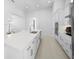 Modern white kitchen features a large island with sink, sleek cabinets, and stainless-steel appliances at 28761 Sweet Persimmon Dr, Wesley Chapel, FL 33543