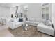 Bright, open-concept living room with modern white decor, plush seating, and abundant natural light at 28761 Sweet Persimmon Dr, Wesley Chapel, FL 33543