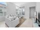 Inviting living room with a plush sectional sofa, a stylish glass coffee table, and natural light flooding through the windows at 28761 Sweet Persimmon Dr, Wesley Chapel, FL 33543