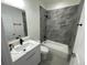 Modern bathroom featuring gray tiling in the shower, white cabinets, and black fixtures at 10153 Wildcat St, Port Charlotte, FL 33981