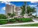 Stunning condominium exterior showcases lush landscaping and a beautiful, multi-story facade, with large windows at 3010 Grand Bay Blvd # 472, Longboat Key, FL 34228