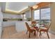 Bright kitchen with white cabinets and a dining area features stunning views for a delightful cooking and dining experience at 3010 Grand Bay Blvd # 472, Longboat Key, FL 34228
