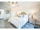 This bedroom features wood-look flooring, a ceiling fan, and a doorway to the bathroom at 328 6Th Ave, Indian Rocks Beach, FL 33785