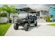 Attractive golf cart is parked in the driveway with a well-manicured lawn and home in the background at 328 6Th Ave, Indian Rocks Beach, FL 33785