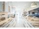 Modern kitchen showcasing white cabinets, marble countertops, gold hardware, and stylish fixtures at 328 6Th Ave, Indian Rocks Beach, FL 33785