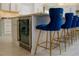 Kitchen island with a beverage cooler and blue upholstered stools with gold legs at 328 6Th Ave, Indian Rocks Beach, FL 33785