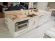 Kitchen island with granite countertop, stainless steel microwave, white cabinets, and gold fixtures at 328 6Th Ave, Indian Rocks Beach, FL 33785