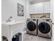 Convenient laundry room equipped with a sink, washer, dryer, and storage cabinets at 328 6Th Ave, Indian Rocks Beach, FL 33785