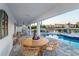 Relaxing covered patio with outdoor dining and seating overlooking a pool and waterfront view at 328 6Th Ave, Indian Rocks Beach, FL 33785