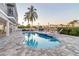 Outdoor pool and patio area with comfortable seating, lush palm trees, and waterfront views at 328 6Th Ave, Indian Rocks Beach, FL 33785