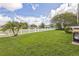 Spacious backyard with a green lawn, a white picket fence, and a mature palm tree at 6935 Runner Oak Dr, Wesley Chapel, FL 33545
