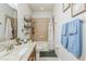 Cozy bathroom showcasing a shower-tub combo, neutral tile, and granite countertop vanity at 6935 Runner Oak Dr, Wesley Chapel, FL 33545