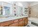 Bathroom featuring a double sink vanity with granite counters and a shower-tub combo at 6935 Runner Oak Dr, Wesley Chapel, FL 33545