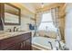 Bright bathroom featuring a soaking tub with bronze fixtures and decorative shower curtain at 6935 Runner Oak Dr, Wesley Chapel, FL 33545