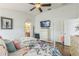 Bright bedroom featuring wood floors, a ceiling fan, and a comfortable floral-themed bed at 6935 Runner Oak Dr, Wesley Chapel, FL 33545