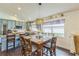 Open dining room features a hanging lamp and views into a modern kitchen with stainless steel appliances at 6935 Runner Oak Dr, Wesley Chapel, FL 33545