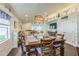 Open dining room features an ornate chandelier, a large window, and views into the adjacent living room at 6935 Runner Oak Dr, Wesley Chapel, FL 33545