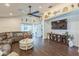 A well-lit living room features a large TV, decor shelves, and sliding glass doors to the outdoor area at 6935 Runner Oak Dr, Wesley Chapel, FL 33545