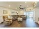 Comfortable living room with a ceiling fan, cozy seating, and sliding glass doors to the outdoors at 6935 Runner Oak Dr, Wesley Chapel, FL 33545