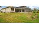 View of the home's backyard featuring a screened-in pool and patio area at 924 Texas St, Englewood, FL 34223