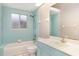 Cozy bathroom featuring blue tiling, vanity sink and mirror, and a bathtub at 924 Texas St, Englewood, FL 34223
