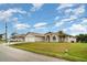 Charming house exterior featuring a two-car garage, well-manicured lawn, and a palm tree at 924 Texas St, Englewood, FL 34223