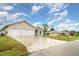 A residential street view showing a two-car garage home with a green lawn and a long driveway at 924 Texas St, Englewood, FL 34223