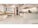 Bright, open kitchen featuring a built-in desk, white cabinets, granite countertops, and tile flooring at 924 Texas St, Englewood, FL 34223