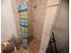 Bathroom shower with tiled walls and brown floor tiles, and a striped shower curtain at 3613 Deleuil Ave, Tampa, FL 33610