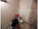 Bathroom showing a toilet, stacked towels, tiled walls, and a laundry basket at 3613 Deleuil Ave, Tampa, FL 33610