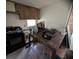 Kitchen with damaged wooden cabinets, black appliances, and a marble countertop at 3613 Deleuil Ave, Tampa, FL 33610