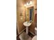 Cozy half bathroom featuring a pedestal sink, tile flooring, and warm wall color at 7620 Tangle Rush Dr, Gibsonton, FL 33534