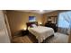 This bedroom is carpeted and features a bed, dresser, and bedside tables with lamps at 7620 Tangle Rush Dr, Gibsonton, FL 33534