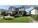 Two-story home with well-manicured lawn, green shrubs and driveway at 7620 Tangle Rush Dr, Gibsonton, FL 33534