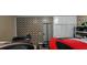 Well-lit garage featuring decorative painted walls, storage solutions, and multiple vehicles at 7620 Tangle Rush Dr, Gibsonton, FL 33534