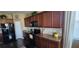 Well-lit kitchen features sleek black appliances, rich wood cabinetry, and modern countertops at 7620 Tangle Rush Dr, Gibsonton, FL 33534