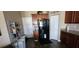 Kitchen area with sleek black refrigerator, dark wood cabinetry, and tile flooring at 7620 Tangle Rush Dr, Gibsonton, FL 33534