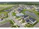 Aerial view of a residential community with a lake, sidewalks, and green spaces between homes at 7163 Talamore Dr, Wesley Chapel, FL 33545