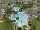Aerial view of community pool and tennis courts surrounded by mature trees at 7163 Talamore Dr, Wesley Chapel, FL 33545