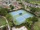 Aerial view of community tennis courts surrounded by trees and nearby community pool at 7163 Talamore Dr, Wesley Chapel, FL 33545