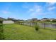 Spacious backyard with pond and fence in residential neighborhood at 7163 Talamore Dr, Wesley Chapel, FL 33545