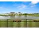Beautiful backyard with pond view and black fence in residential neighborhood at 7163 Talamore Dr, Wesley Chapel, FL 33545