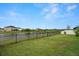 The backyard features a well-maintained lawn, fenced perimeter, and serene pond view at 7163 Talamore Dr, Wesley Chapel, FL 33545