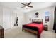 Teen bedroom with a bed with red bedding, side table and ensuite bathroom with black fixtures at 7163 Talamore Dr, Wesley Chapel, FL 33545