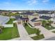 Aerial view of home featuring a three-car garage, well-manicured lawn, and attractive landscaping at 7163 Talamore Dr, Wesley Chapel, FL 33545