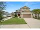 Inviting two-story home boasting a well-manicured lawn, three-car garage, and a striking red front door at 7163 Talamore Dr, Wesley Chapel, FL 33545