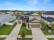 Aerial view of home featuring a three-car garage, well-manicured lawn, and attractive landscaping at 7163 Talamore Dr, Wesley Chapel, FL 33545