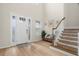 Bright foyer featuring hardwood floors, a staircase, and stylish decor at 7163 Talamore Dr, Wesley Chapel, FL 33545